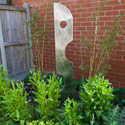Contemporary stainless steel sculpture in a town house garden.