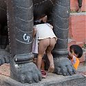 Children playing on statue, Durbar Square, Kathmandu, Nepal.