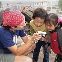 Children looking at themselves on a digital camera, China.